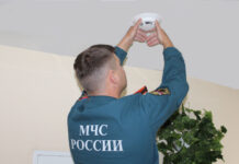 Слюсарь призвал проверить пожарную безопасность на рынках и в ТЦ сотрудник МЧС устанавливает пожарный извещатель // фото: 70.mchs.gov.ru