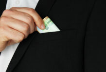 Ростовчанин требовал 3 млн рублей у владельца сети аптек Мужчина прячет деньги в карман //Фото Freepik, wirestock